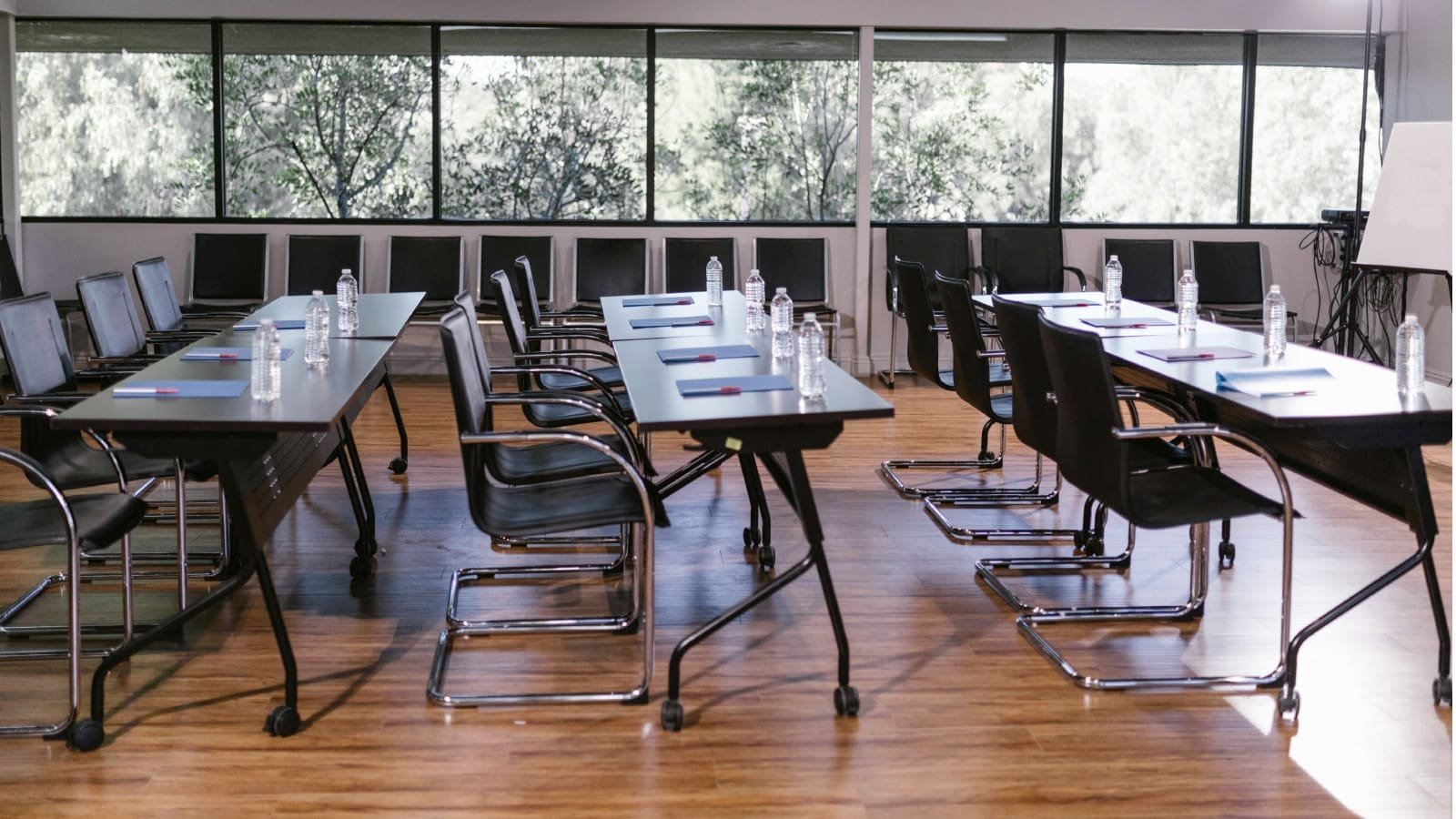 Modern empty classroom with arranged chairs, tables, and presentation equipment in a professional training environment